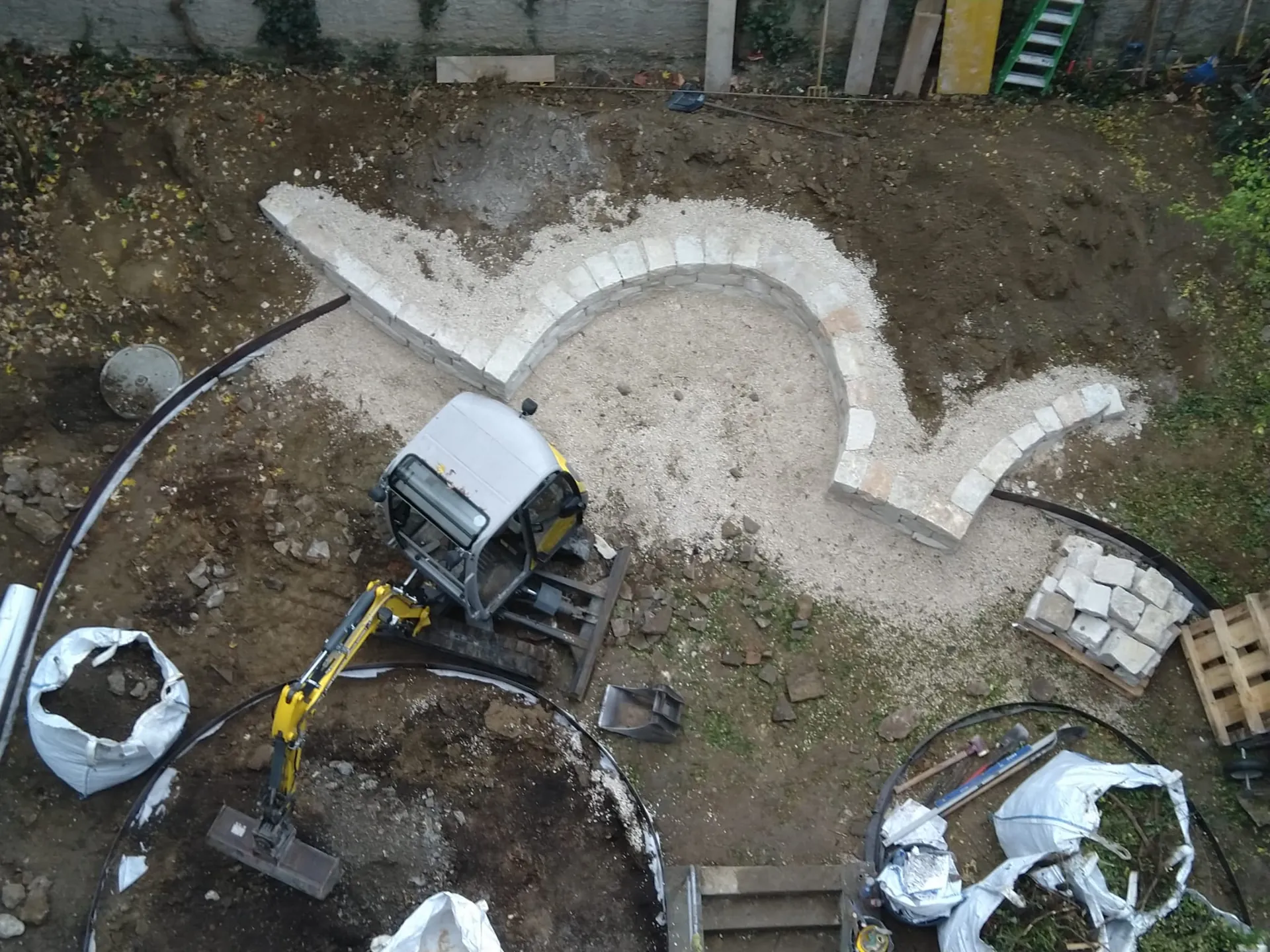 Gartenneuanlage mit Bagger und Trockenmauer aus der Luft