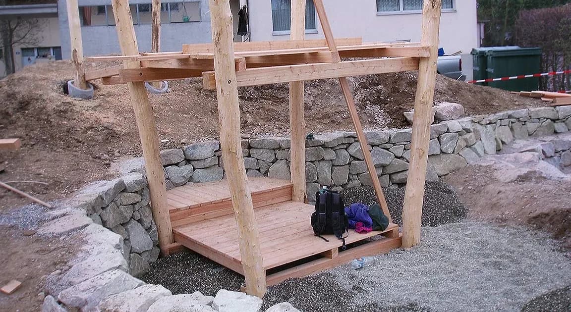 Gartenpavillon mit Holzkonstruktion und Trockenmauer