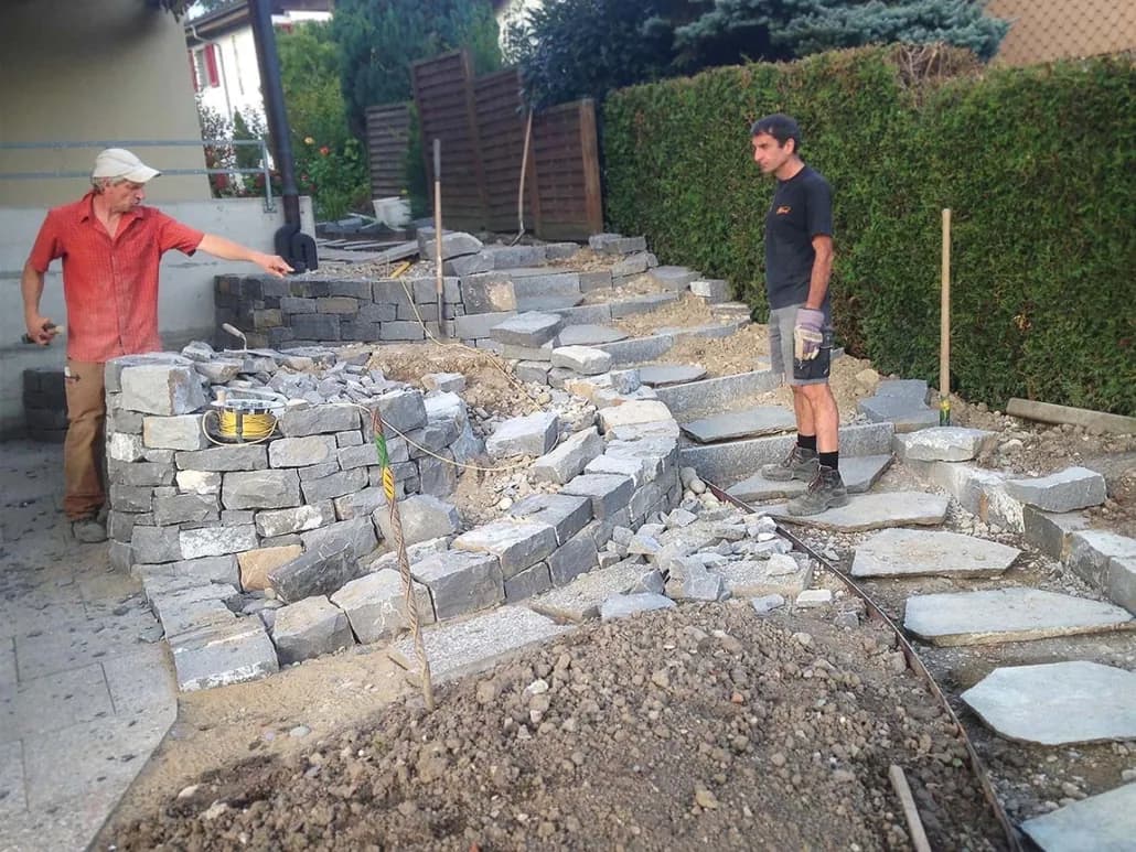 Gartenbauer-Team beim Bau einer Trockenmauer