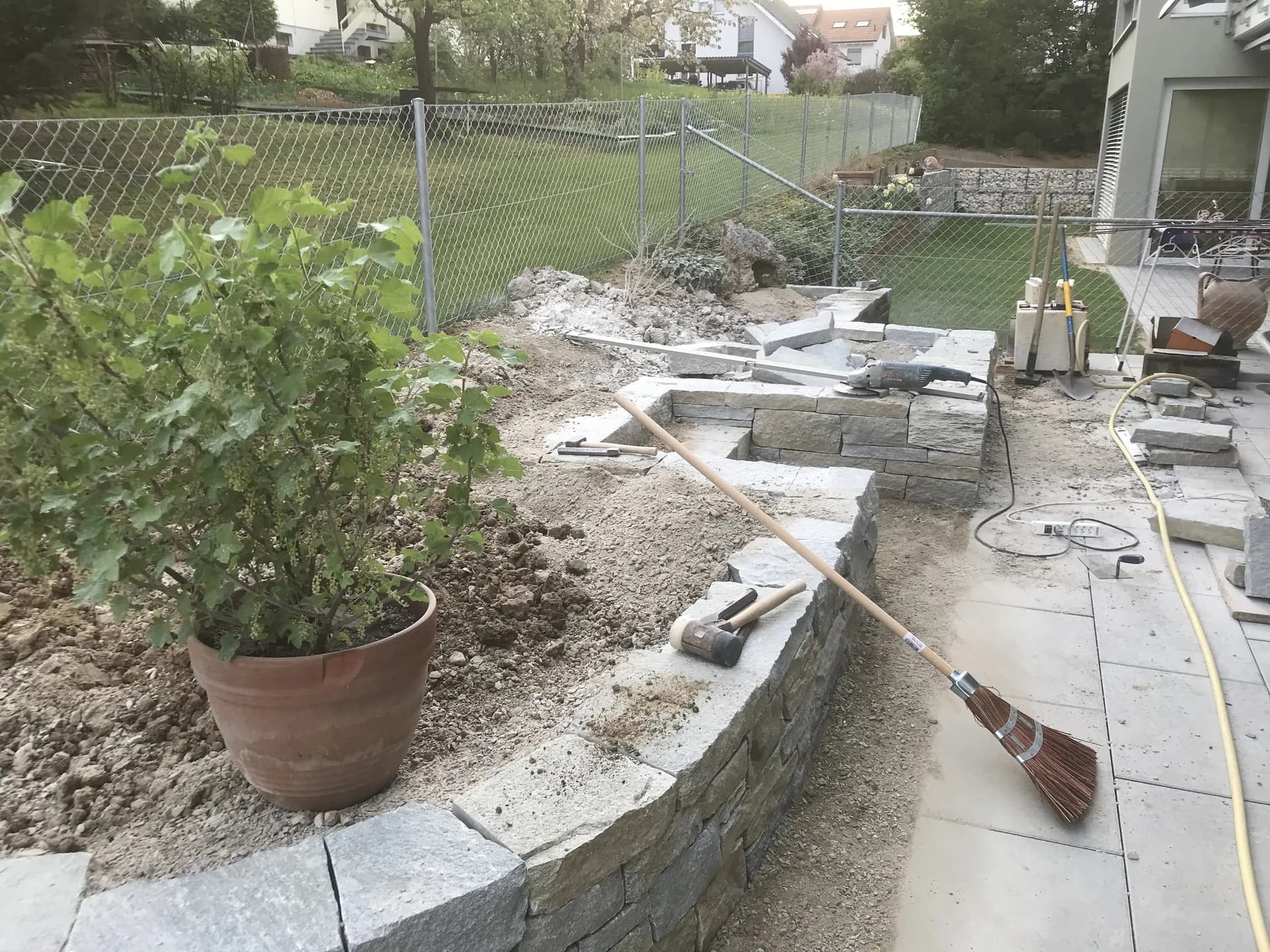 Trockenmauer-Hochbeet im Rohbau mit Werkzeug